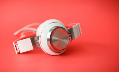 White modern headphones on coral background concept