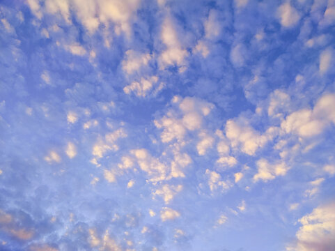 Bright clouds in evening sky. Vibrant photo of clouds illuminated by setting sun