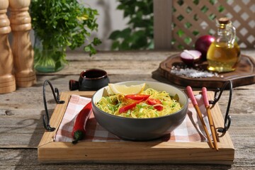 Stir-fry. Tasty noodles with vegetables and meat in bowl served on wooden table