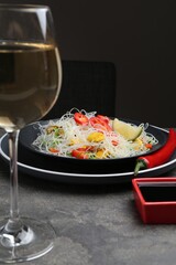 Stir-fry. Tasty rice noodles with meat and vegetables served on grey textured table