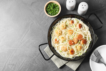 Delicious scallop pasta with green onion served on grey table, flat lay. Space for text