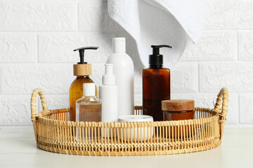 Bath accessories. Personal care products on white table near brick wall