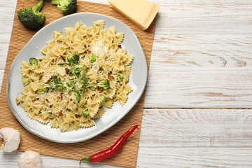 Vegetarian meal. Tasty pasta with fresh vegetables and cheese on white wooden table, top view. Space for text