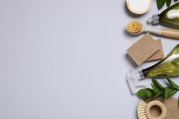 Flat lay composition with different cleaning supplies on light gray background, space for text