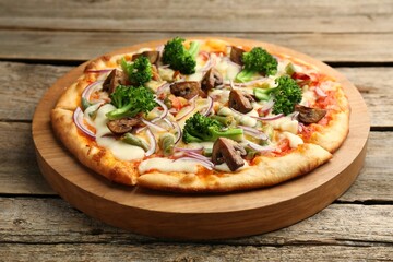 Board with delicious vegetarian pizza on wooden table, closeup