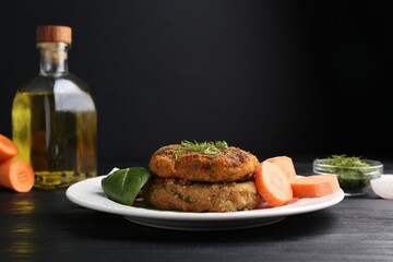 Vegetarian product. Tasty carrot cutlets served on black wooden table
