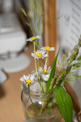 petites fleurs des champas dans un bocal sur un bureau