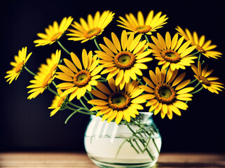A vase filled with yellow daisies.