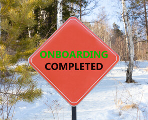 Onboarding completed symbol. Concept words Onboarding completed on beautiful red road sign. Beautiful forest snow blue sky background. Business onboarding completed concept. Copy space.