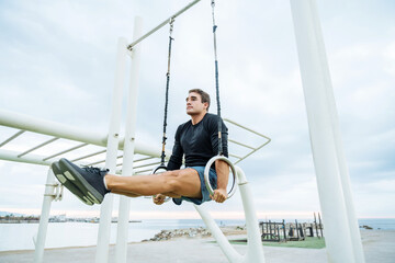 Atlethic man doing functional training exercise at the outdoor gym - Sportive male adult doing sport