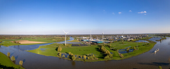 Dutch landscape panorama of wind turbine and solar panels with waterway intersection of river...