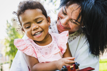 Beautiful happy african american family bonding at the park - Playful black grandmother hugging her...