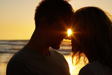 Couple, love and kiss at beach with silhouette for date or summer holiday and bonding in Florida....