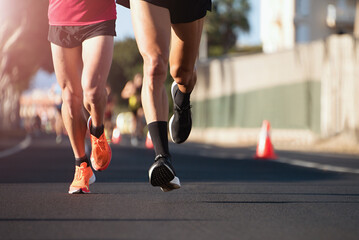 Marathon running in the light of morning. People feet on city road