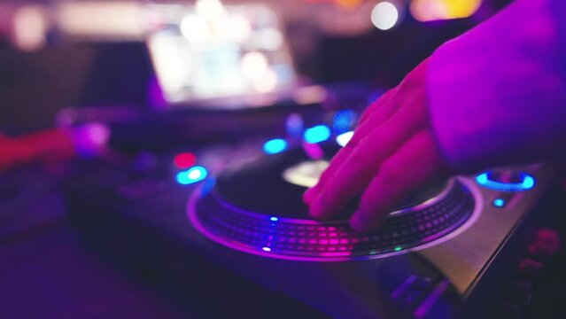 dj playing on controller at nightclub, man mixing music at party with turntable emulation