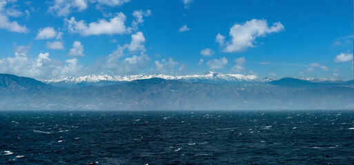 Sailing past the costa tropical coast of Andalusia with the snow-capped sierra nevada mountains, Spain