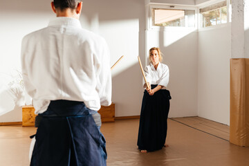 Female Martial Artists Engage in Wooden Sword Practice in a Bright Dojo