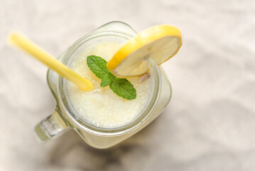 Fresh lemonade in glass jar on sand beach. Refreshing lemon drink, top view. - 783081336