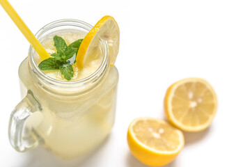 Fresh lemonade in glass jar with straw. Refreshing lemon drink isolated on white background.