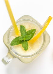 Close up of fresh lemon drink with straw. Jar glass of lemonade on white background.