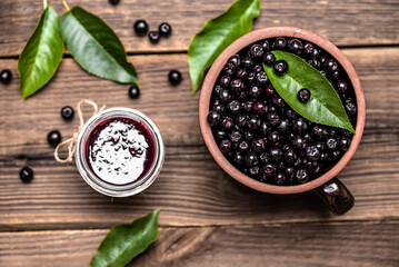 Aronia jam and fresh berry on wooden table, top view. - 783081766