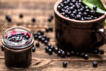 Aronia jam and fresh berry on wooden table. - 783081965