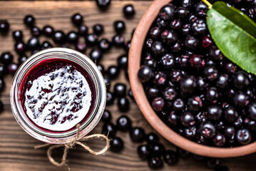 Aronia jam and fresh berry on wooden table. - 783081973