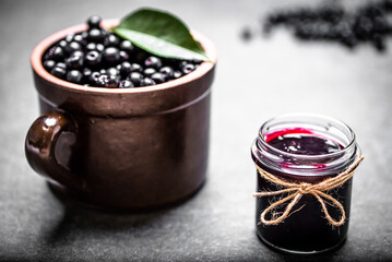 Aronia jam and fresh berry on stone table. - 783082567