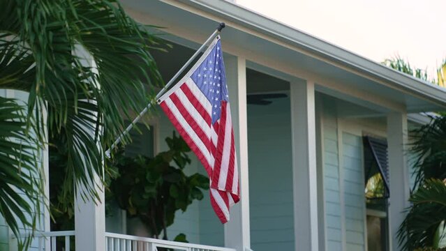 American national flag waving in front yard of Florida private house. Aerial view of USA stars and stripes spangled banner as symbol of democracy