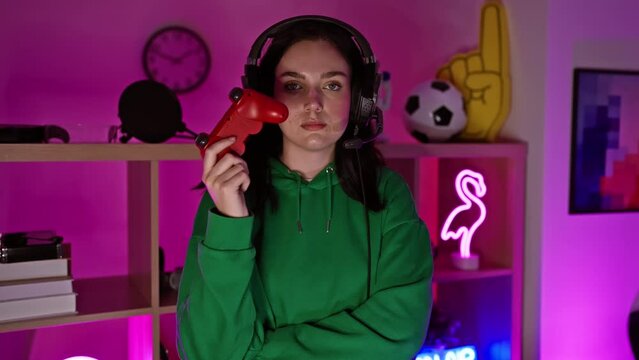 A young woman with a game controller in a neon-lit gaming room at night