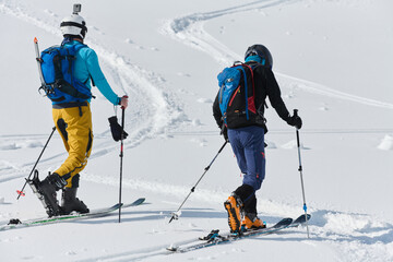 Alpine Ascent: Two Professional Skiers Conquer Snowy Peaks as a Determined Team. - 783093153