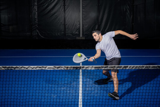 Padel player hitting ball with a racket - Powered by Adobe