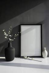 Empty black frame on the table, dark wall, minimalism. Vertical orientation.