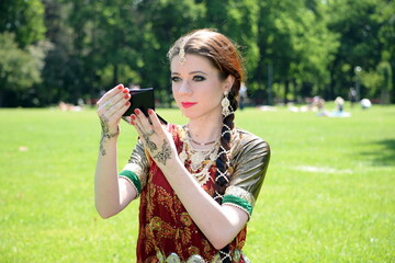 Beautiful colorful bollywood woman with colorful costume portrait at outdoor park. 