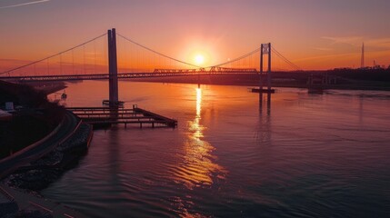Fototapeta na wymiar Sunset Glow Over Serene River with Suspension Bridge
