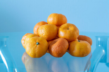 A pile of tangerines on a table. The tangerines are piled on top of each other, creating a pyramid...