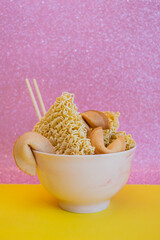 A bowl with dried noodles, fortune cookies and chopsticks - 783101382