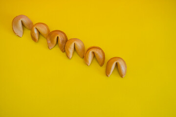 A fortune cookies are laid out in a line on yellow background. Minimalism and creative concept - 783101582