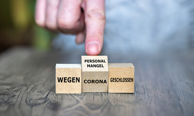 Hand turns cube and changes the German expression 'wegen Corona geschlossen' (closed due to corona)...