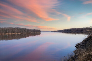 Long view of calm river at dusk, pink clouds, blue sky, clouds reflecting, nobody