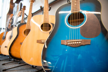 Low angle view of Guitars on sale. Stack of musical instruments . Blue and an yellow guitars