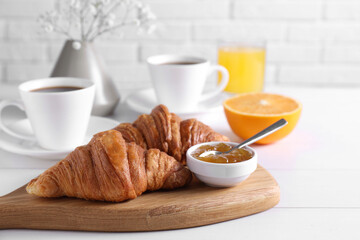 Croissants and jam on white wooden table. Tasty breakfast