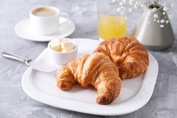 Tasty breakfast. Fresh croissants and butter on grey table, closeup