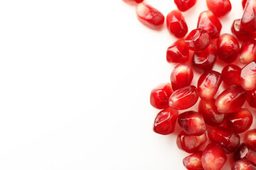 Many ripe juicy pomegranate grains on white background, flat lay. Space for text