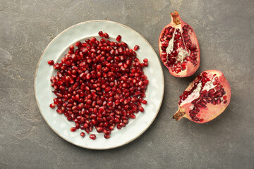 Tasty ripe pomegranate and grains on grey table, flat lay