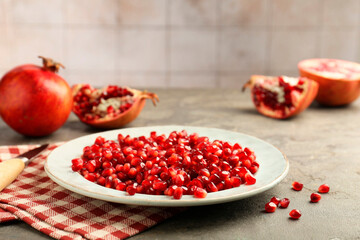 Tasty ripe pomegranate grains on grey table