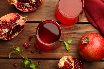 Tasty pomegranate juice in glasses and fresh fruits on wooden table, flat lay