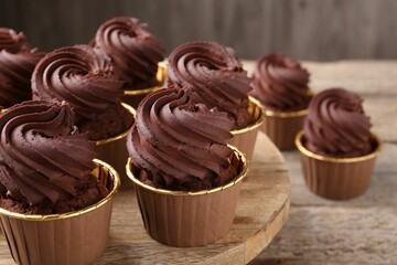 Delicious chocolate cupcakes on wooden table, closeup