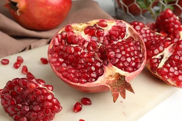Fotobehang Piece of fresh pomegranate and seeds on white table, closeup © New Africa