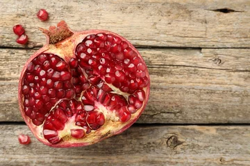 Fotobehang Cut fresh pomegranate on wooden table, top view. Space for text © New Africa